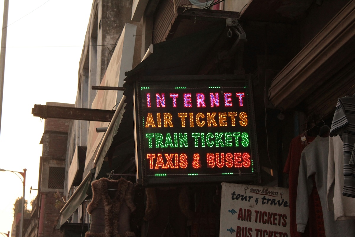 Illuminated sign for a travel agency advertising air tickets, train tickets, taxis and buses