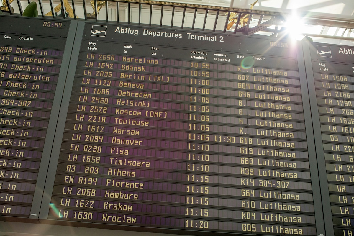 Airport departures board showing flight times and gates