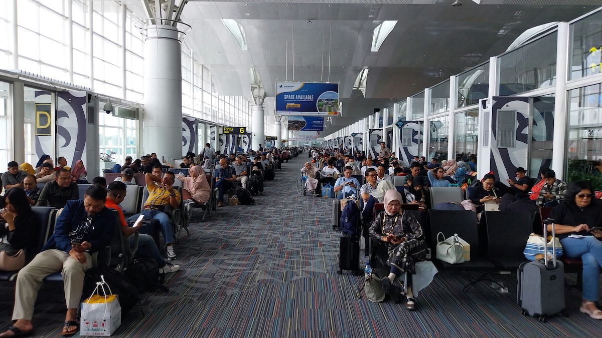 Passengers waiting at an airport departure gate seating area