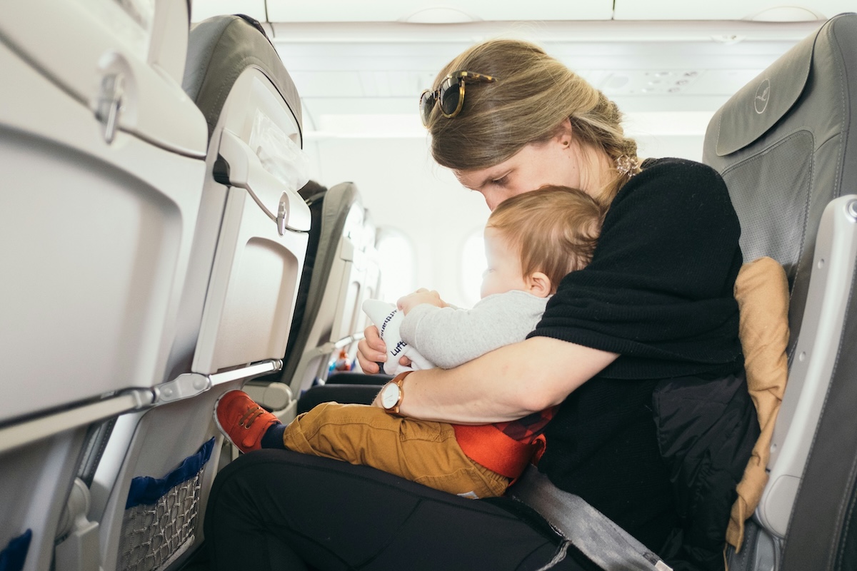 Mother holding a baby on an airplane during flight