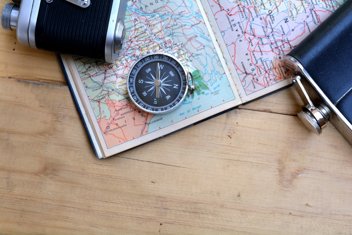Compass and camera resting on an open paper map